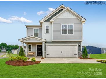 Two-story home with gray siding, two-car garage, and landscaping at 11027 Daisy Ct, Charlotte, NC 28262