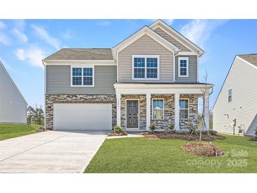 New construction home displaying stone and gray siding, an attached garage, and a well-maintained lawn at 1171 Blackburn Cir, Edgemoor, SC 29712