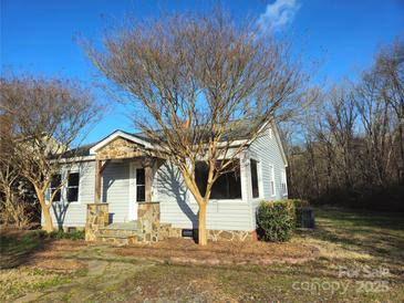 Charming bungalow-style home featuring stone accents, mature trees, and a well-maintained front yard at 13655 Broadway Ave, Midland, NC 28107