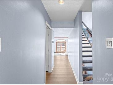 Light-filled hallway with wood floors, leading to stairs and lake view at 5190 Corbin Ln, Hickory, NC 28601