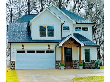 Two-story white farmhouse-style home with a gray roof and a brick base at 604 N Providence St, Waxhaw, NC 28173