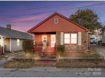 Charming brick home featuring a cozy front porch and well-maintained landscaping at 630 N Moran St, Gastonia, NC 28052