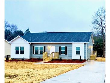 Charming single-story home with gray siding, black shutters, and newly seeded lawn at 823 Wellwood Ave, Statesville, NC 28677