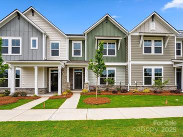 Charming townhomes with varied siding, stone accents, manicured lawns, and inviting sidewalks on a sunny day at 10119 Mamillion Dr, Huntersville, NC 28078