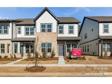 Two-story townhome with modern facade, landscaping, and inviting front porch at 1182 Lost Cove Rd, Indian Land, SC 29707