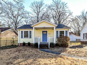 Cute yellow house with blue shutters, front porch, and small yard at 1716 Dallas Ave, Charlotte, NC 28205