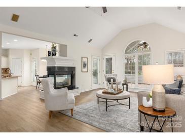 Bright living room with vaulted ceilings, modern furnishings, and a cozy fireplace at 17521 Cambridge Grove Dr, Huntersville, NC 28078