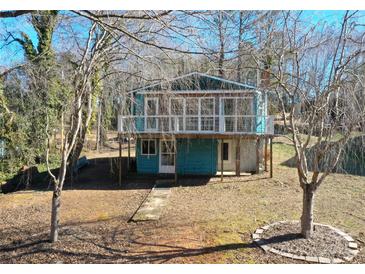 Quaint lakefront cottage with elevated deck and surrounding trees at 198 Clouse Ln, Taylorsville, NC 28681