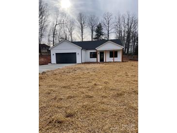 Newly constructed home with a white exterior, black garage door, and a covered porch at 2045 Cordia Cir, Newton, NC 28658