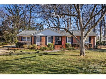 Brick ranch home with landscaped lawn and mature trees at 3019 Parkstone Dr, Charlotte, NC 28210