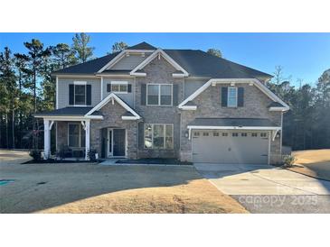 Inviting two-story home with stone accents, covered porch, and attached two-car garage at 5057 Spratt Rd, York, SC 29745