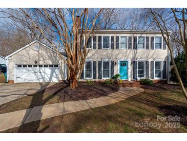 Charming two-story home featuring a bright blue front door, attached garage, and well-maintained landscaping at 523 Fence Post Ln, Matthews, NC 28105