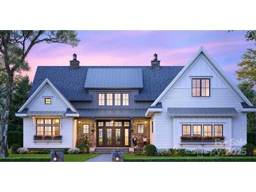 Two-story farmhouse with gray metal roof, white siding, and large windows at 7909 Plantation Falls Ln, Charlotte, NC 28227