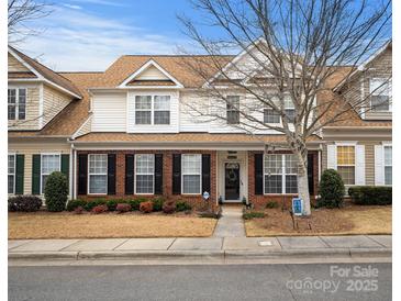 Two-story townhome with brick and siding exterior, welcoming front porch, and landscaping at 10122 Oxford Landing Ln, Charlotte, NC 28270