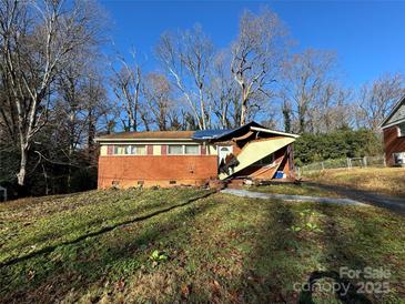 Brick ranch house with significant roof damage and needs major repairs at 1016 Bramble Pl, Charlotte, NC 28208