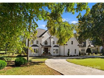 Elegant two-story home with a white brick facade and circular driveway at 12217 Pine Valley Club Dr, Charlotte, NC 28277