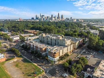 Aerial view of a modern apartment building with city skyline in the background at 1315 East Blvd # 203, Charlotte, NC 28203