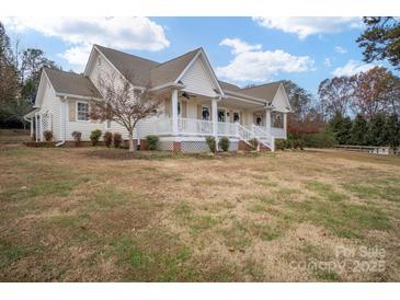 Inviting exterior view of a charming home with a wraparound porch and manicured lawn, perfect for relaxing and entertaining at 160 Pampas Ln, Mooresville, NC 28117