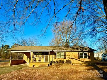 Ranch style brick home with carport and mature trees at 1824 N Charlotte Ave, Monroe, NC 28110