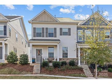 Two-story townhome with gray and beige exterior, landscaping, and walkway at 4020 Harmony Hills Dr, Matthews, NC 28104