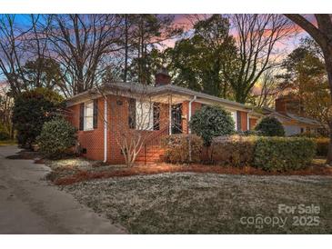 Brick Ranch home with landscaping, partially covered in snow at 4419 Halstead Dr, Charlotte, NC 28209