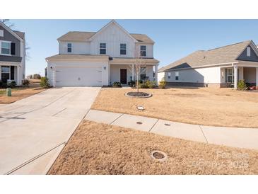 Two-story home with white siding, a two-car garage, and a well-maintained lawn at 450 Caleb St, Monroe, NC 28110