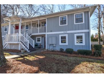 Two-story condo building with gray siding, white trim, and a stairway at 7608 Woods Ln # 12, Cornelius, NC 28031