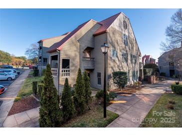 Charming condo complex with mature landscaping, sidewalks, and a striking metal roof at 9037 J M Keynes Dr # 23, Charlotte, NC 28262