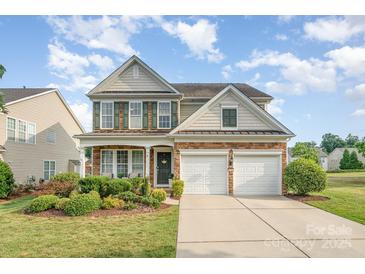 Two-story house with stone and shingle accents, two-car garage, and landscaped front yard at 1344 Middlecrest Nw Dr, Concord, NC 28027