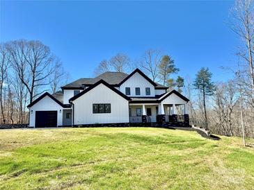 Stunning new construction home with black trim, bright white siding, and a covered porch at 177 Olympia Dr, Mooresville, NC 28117
