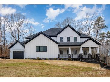 Stunning modern farmhouse-style home with white siding, black trim, and professional landscaping at 177 Olympia Dr, Mooresville, NC 28117