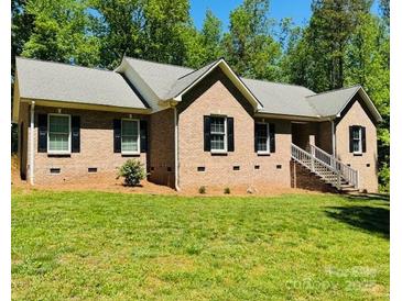 Lovely brick home with a well-manicured lawn and traditional architectural details at 395 Paulownia Dr, China Grove, NC 28023