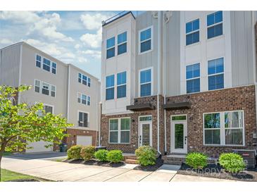 Charming townhome featuring brick accents, a welcoming entryway, and manicured landscaping at 448 E 16Th St, Charlotte, NC 28206