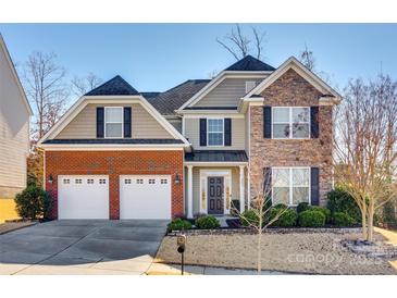 Brick and stone two-story house with a three-car garage and landscaping at 4897 Annelise Dr, Harrisburg, NC 28075