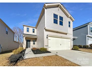Two-story house with light beige vinyl siding, a two-car garage, and landscaping at 6848 Good News Dr, Charlotte, NC 28215