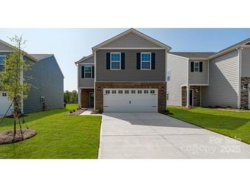 Two-story home with gray and brown siding, two-car garage, and a well-manicured lawn at 3028 Ora Smith Rd, Lincolnton, NC 28092