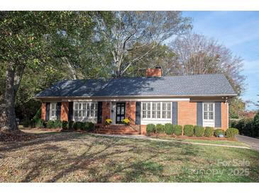 Brick ranch house with a landscaped lawn and mature trees at 4308 Glenfall Ave, Charlotte, NC 28210