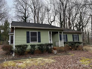 Ranch home with green siding, a covered porch, and landscaping at 4452 Huntington Dr, Gastonia, NC 28056