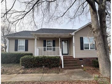 Charming ranch home with landscaped yard and white porch at 844 Turning Point Ln, Concord, NC 28027