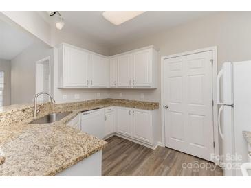 Well-lit kitchen features granite counters, white cabinets, and wood-look flooring at 14967 Santa Lucia Dr, Charlotte, NC 28277