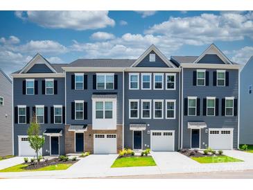 Townhome exteriors feature blue siding, black shutters, white garage doors, and manicured lawns at 3036 Arbor Ash St # 1022B, Charlotte, NC 28208