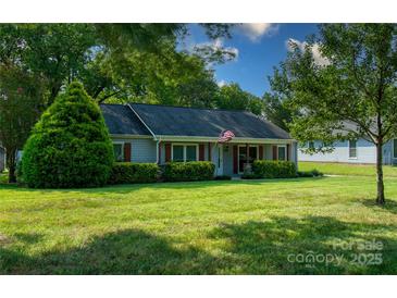 Charming ranch home with gray siding, stone accents, and a well-manicured lawn at 11828 Mirror Lake Dr, Charlotte, NC 28226