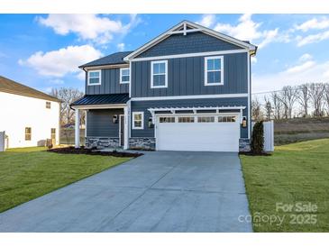 Two-story house with gray siding, white garage door, and landscaping at 3040 Swallowtail Ln # 36, Kannapolis, NC 28083