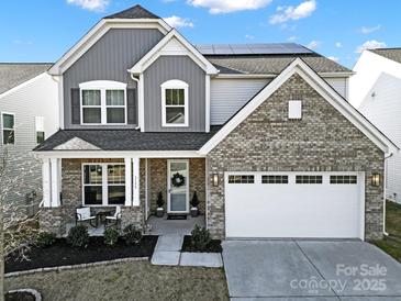 Beautiful two-story home with gray and brick exterior, well-maintained lawn, and a two-car garage at 3155 Pinehills Way, Mount Holly, NC 28120