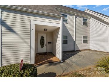 Inviting exterior of a light beige townhouse with a covered entryway and small patio at 9153 Spyglass Pl # B, Charlotte, NC 28214