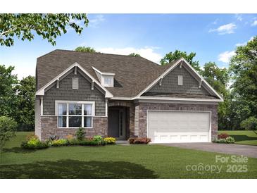 Charming exterior of home featuring stone and grey wood accents, a manicured lawn, and an attached two-car garage at 148 Prestwick Way # 21, Mooresville, NC 28115