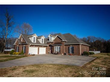 Charming brick home boasts a two-car garage and meticulously maintained landscaping at 219 Society Rd, Statesville, NC 28625
