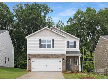 Two-story home with a stone veneer base, white siding, and a two-car garage at 5219 Reedy Ridge Rd, Charlotte, NC 28215