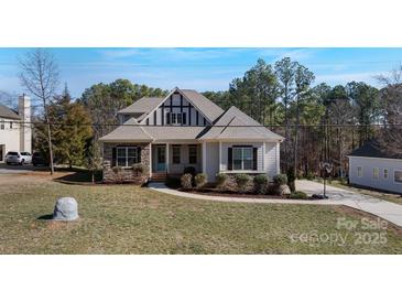 Charming two-story home featuring a stone and siding facade, well-maintained landscaping, and a welcoming entrance at 704 Kenway Loop, Mooresville, NC 28117