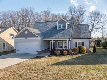 Gray siding two-story house with a white garage door and landscaping at 102 Lake George Dr, Shelby, NC 28152